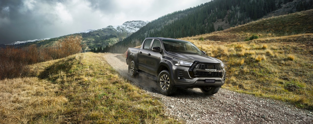 Powerful and dynamic front 3/4 shot of commercial Hilux model in beautiful mountain scenery