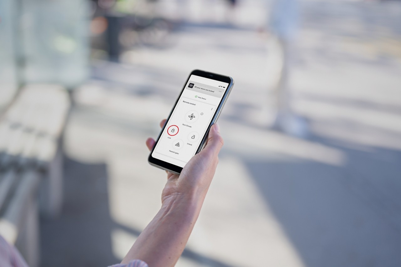 Eine Hand hält ein Smartphone mit der Seite «My Garage» der TOYOTA MyT-App. Sie zeigt verfügbare Connected Services.